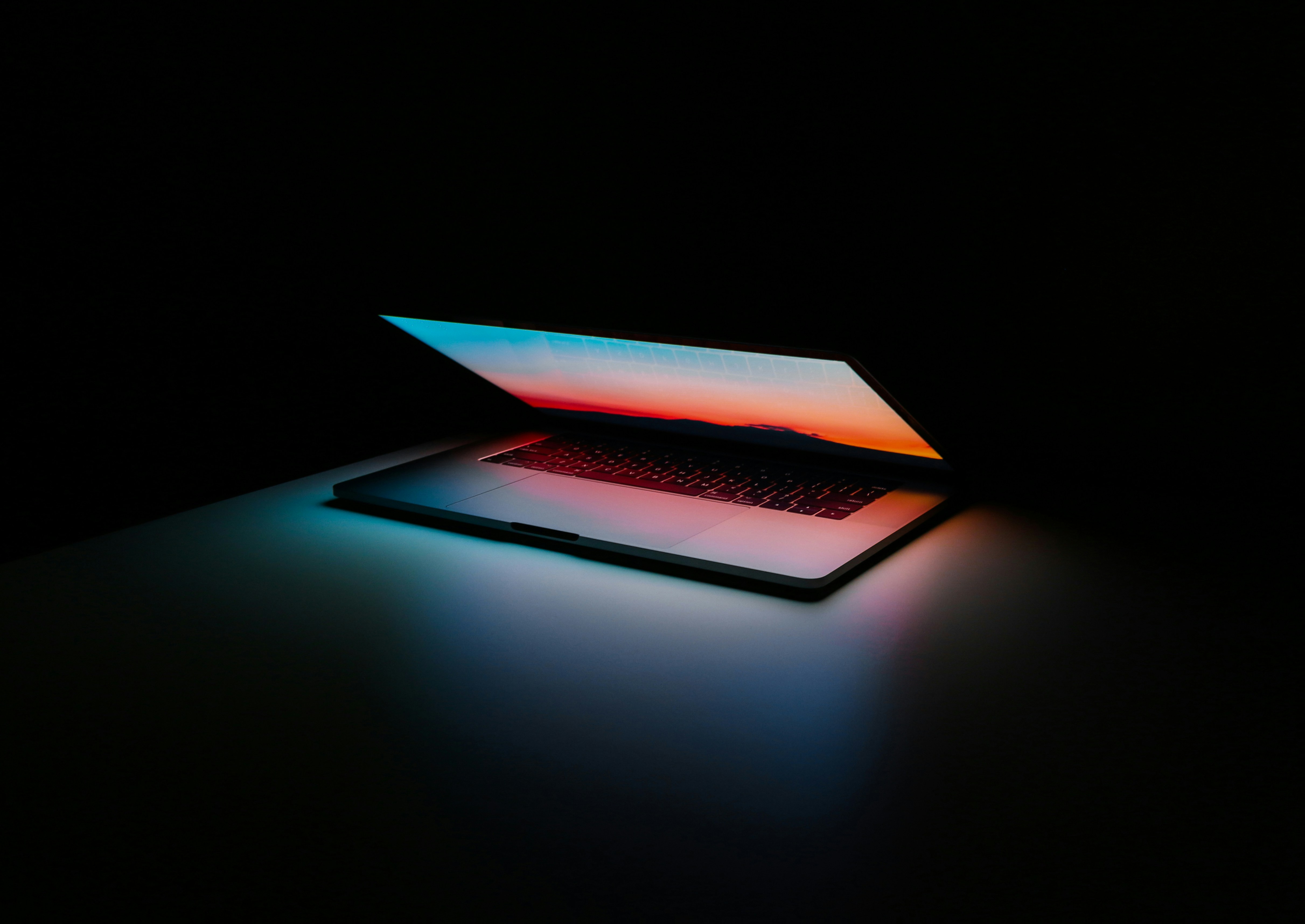 A laptop screen glowing in a dark room.