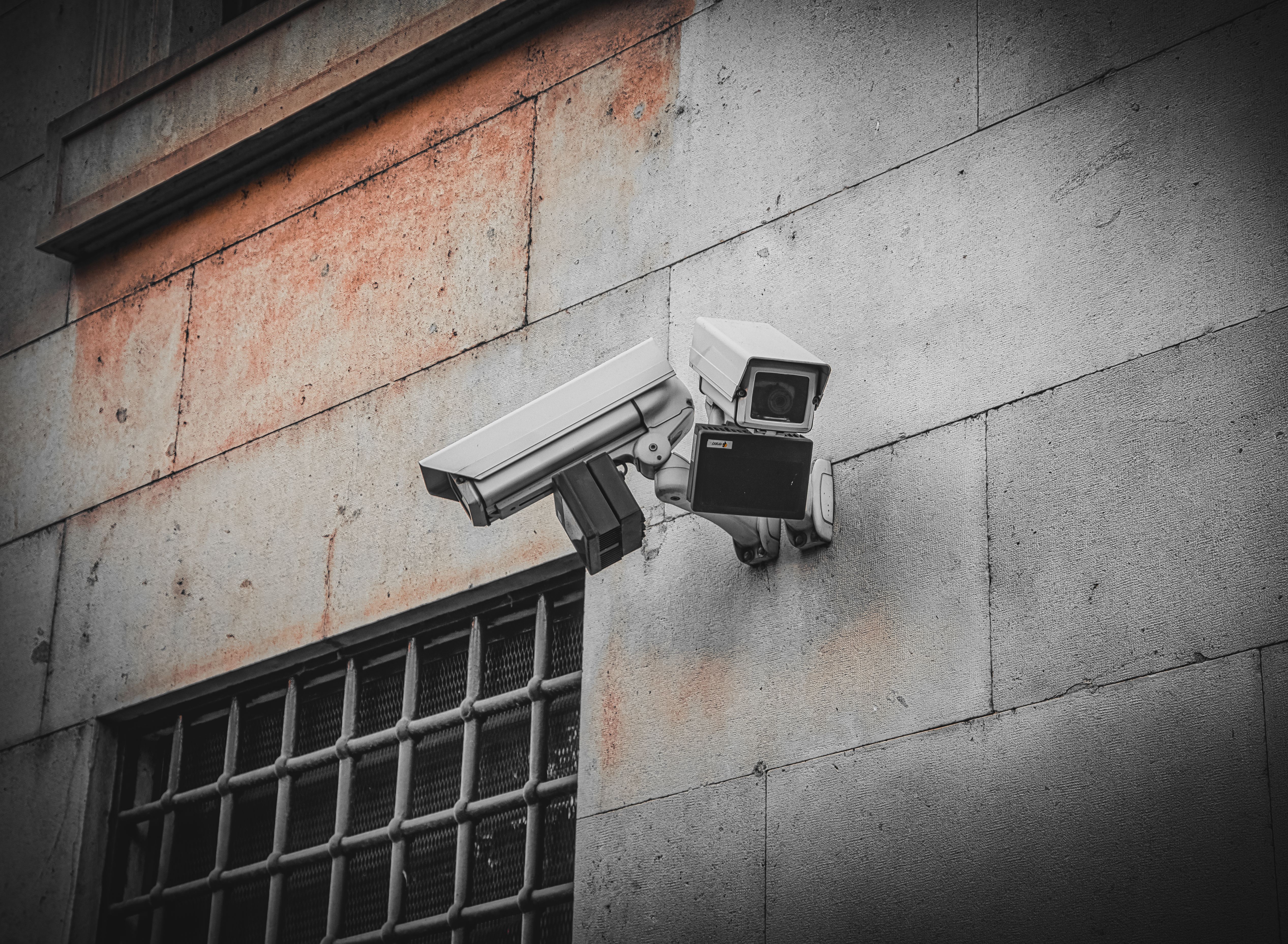 Surveillance cameras mounted on a concrete wall.